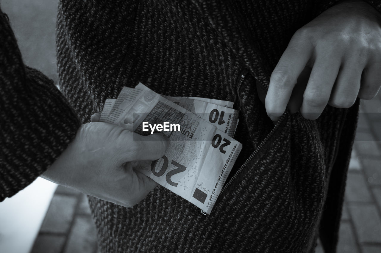 midsection of woman holding paper currencies