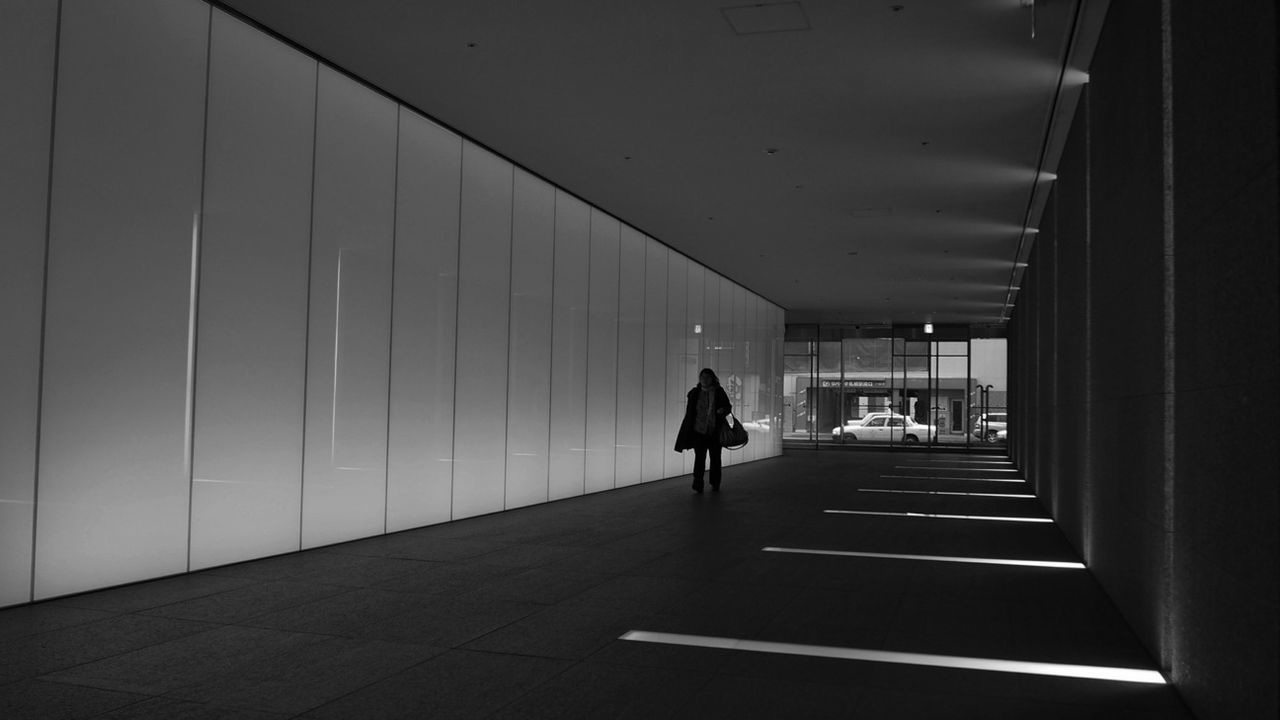 Woman walking on walkway in modern building