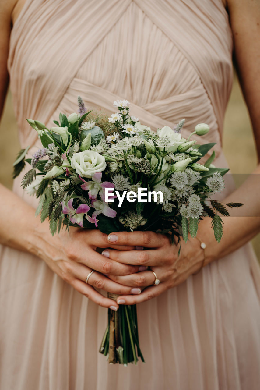 Midsection of woman holding flower bouquet