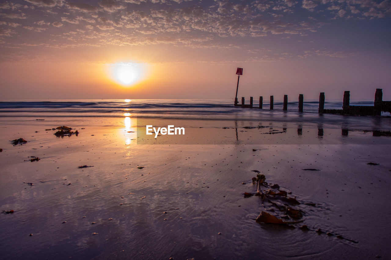 SCENIC VIEW OF SEA AT SUNSET