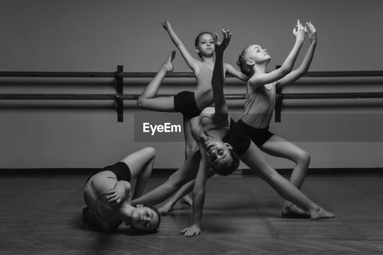 Black and white image of a group of modern little ballerinas standing in a modern dance pose. 