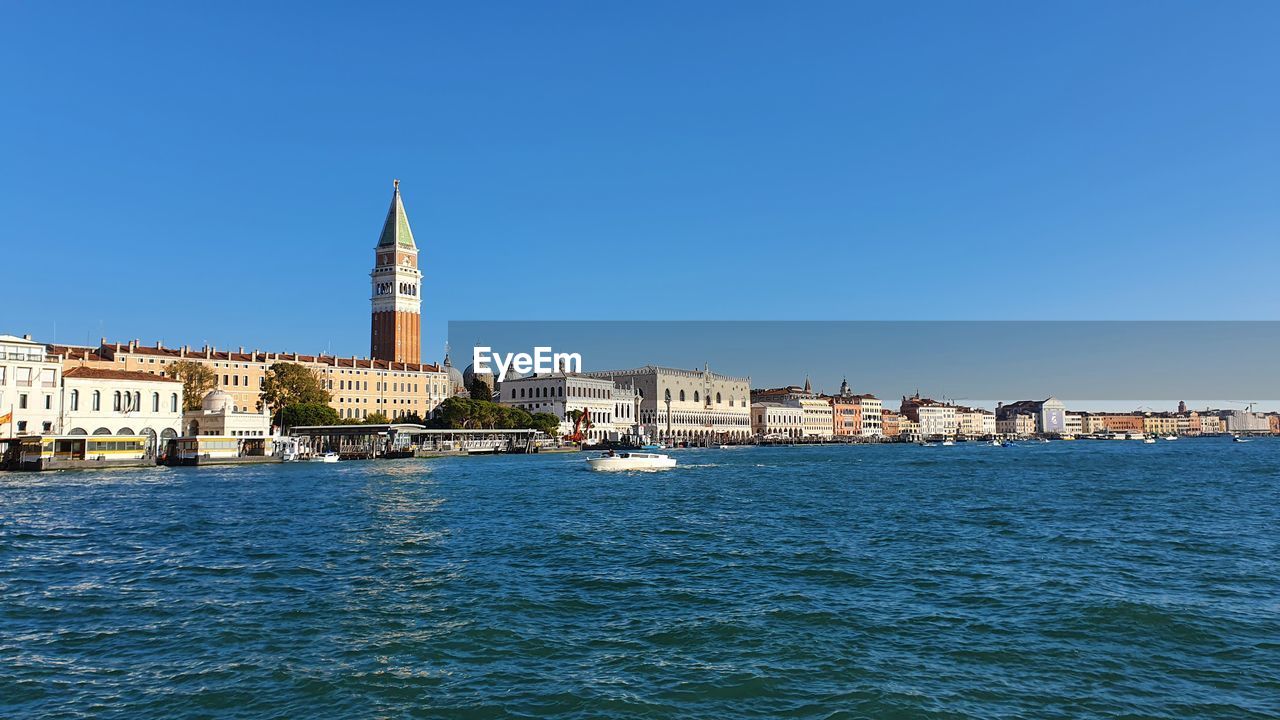 architecture, built structure, building exterior, water, city, sky, building, travel destinations, sea, clear sky, blue, nature, travel, tower, waterfront, tourism, no people, cityscape, coast, horizon, place of worship, day, sunny, history, the past, harbor, religion, copy space, outdoors, bay, skyline, landmark, transportation, town, vacation, bell tower, nautical vessel, sunlight