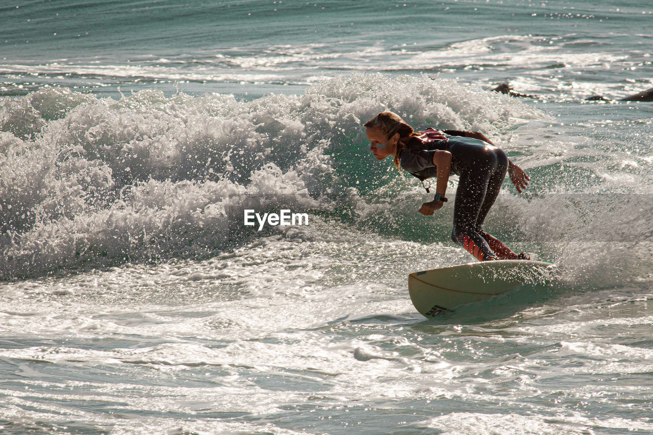 Rear view of woman surfing in sea