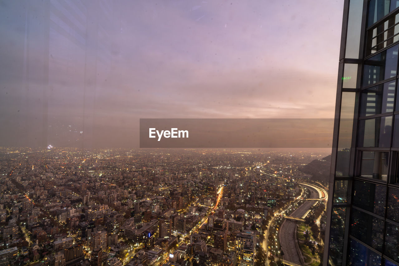 High angle view of illuminated cityscape against sky during sunset