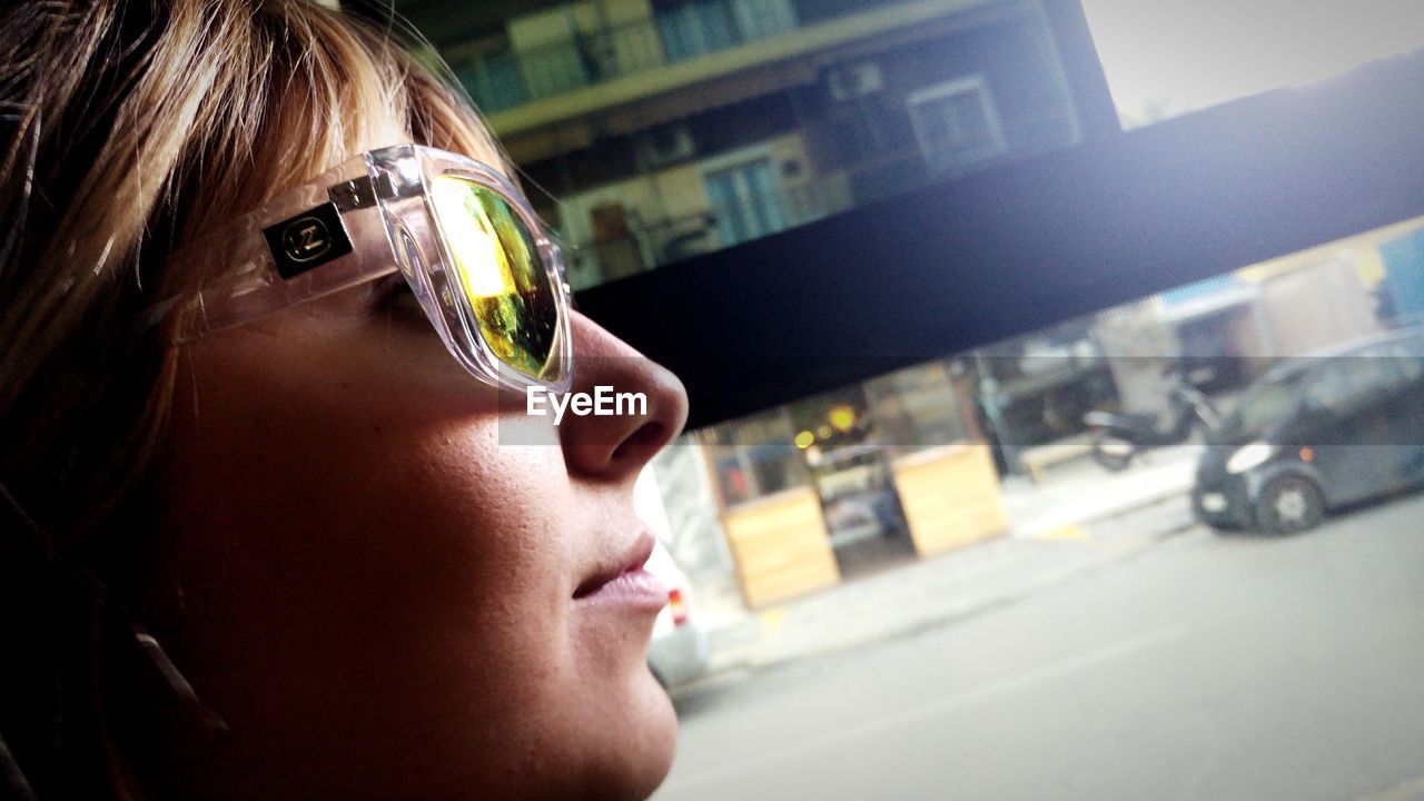 Close-up of woman wearing sunglasses in city