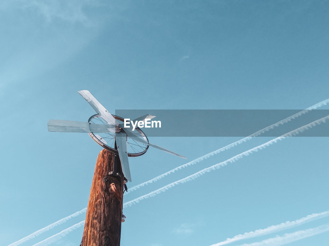 Low angle view of windmill against blue sky