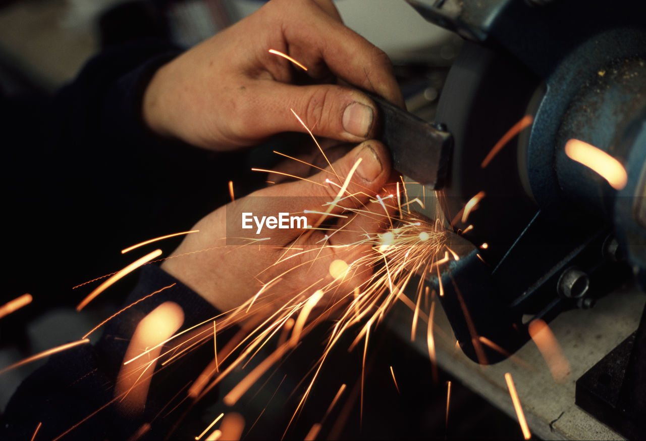 Sparks emitting while worker grinding iron