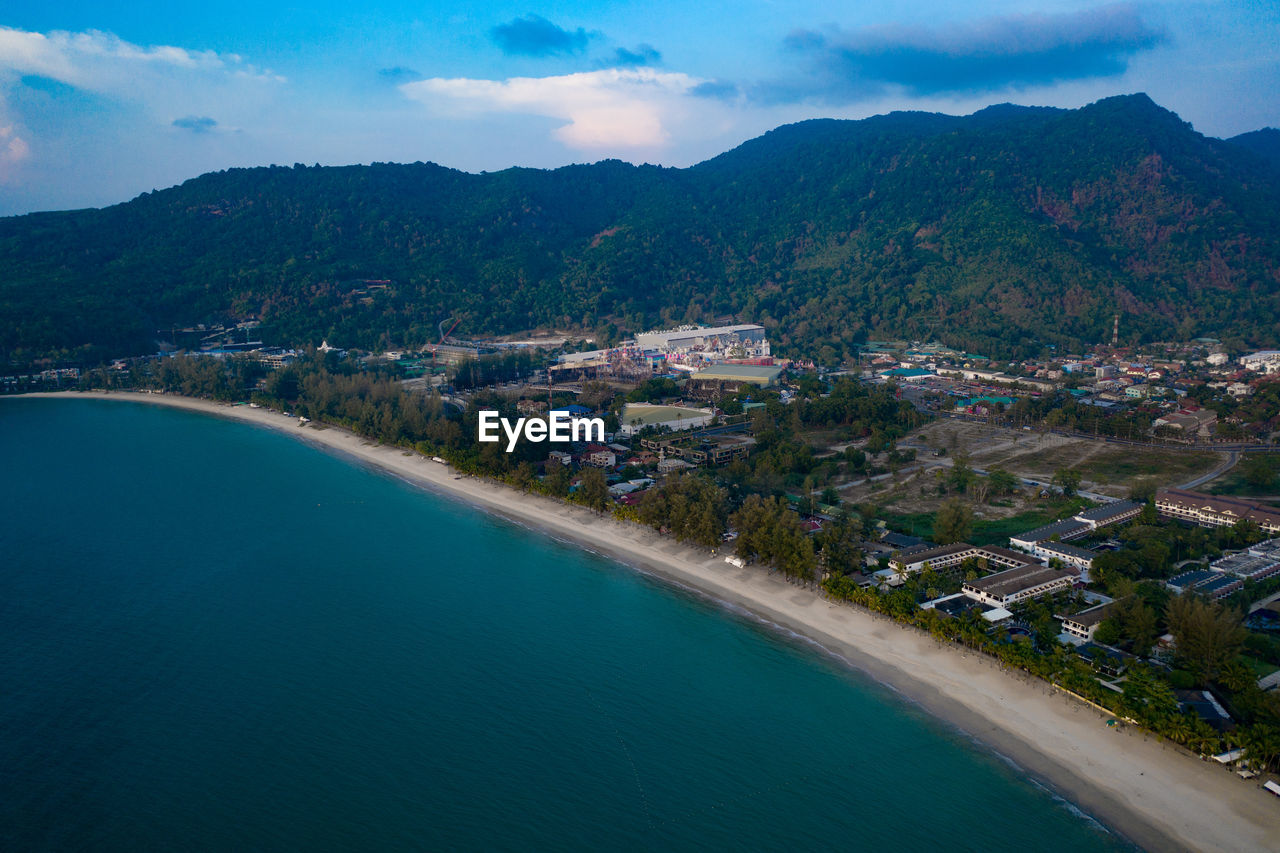 HIGH ANGLE VIEW OF SEA AMIDST BUILDINGS AGAINST SKY