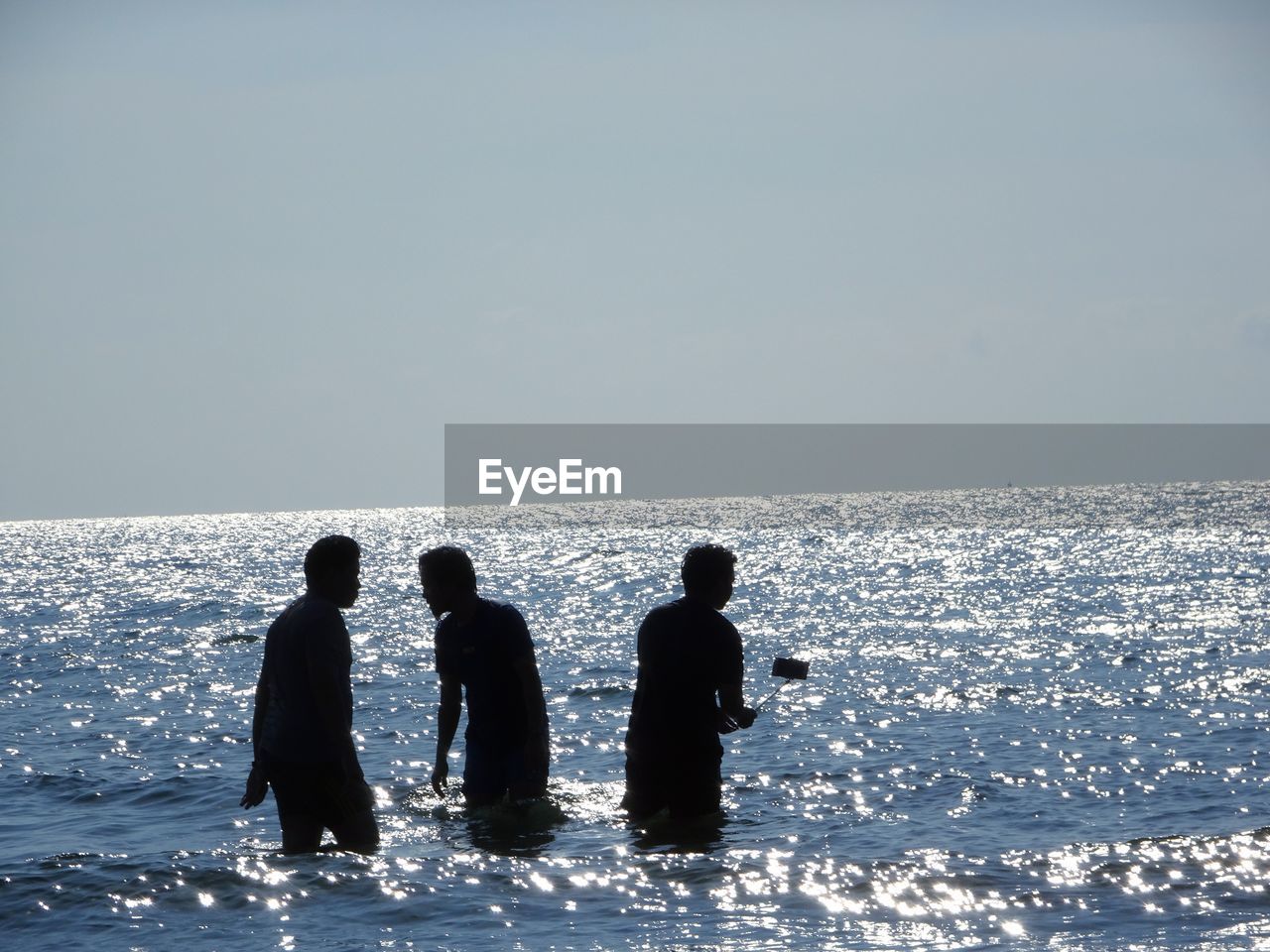 PEOPLE IN SEA AGAINST CLEAR SKY