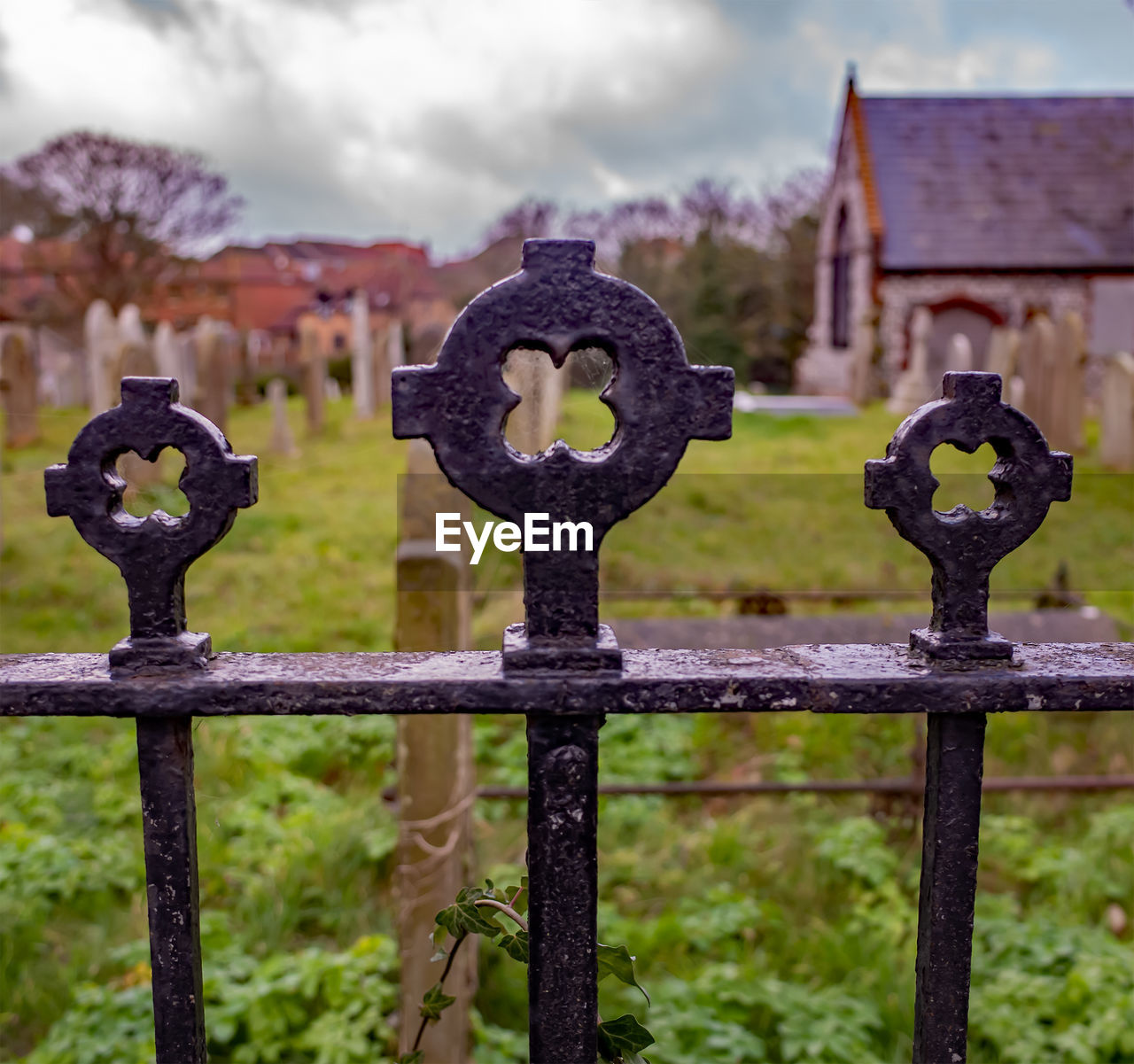 Close-up of metal fence in cemetery