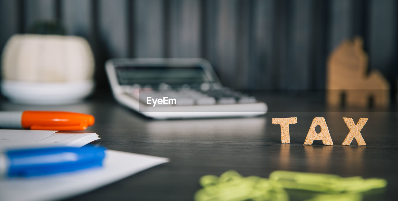 Close-up of text and calculator on table