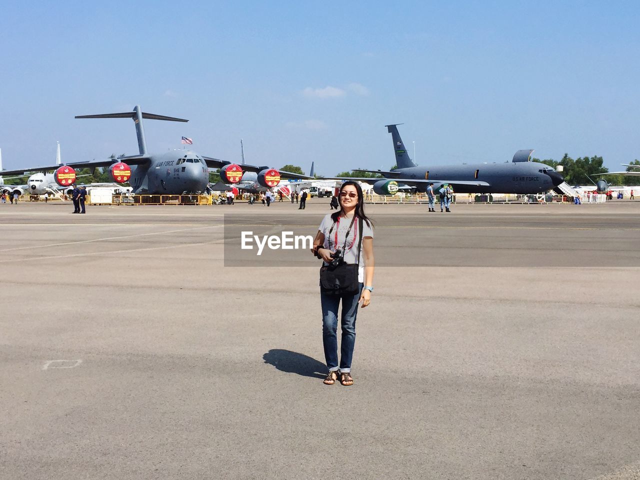 Woman at airport runway against sky