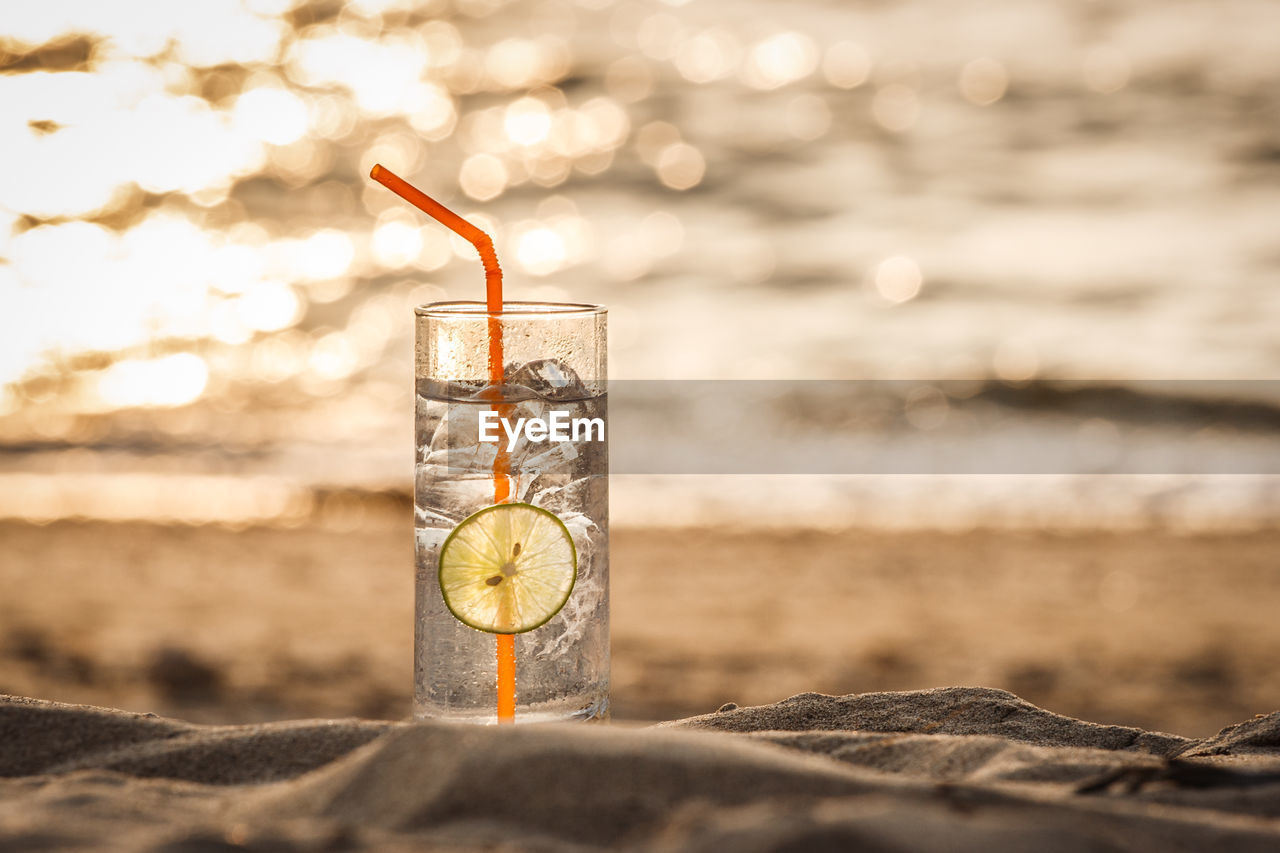 GLASS OF WATER ON BEACH