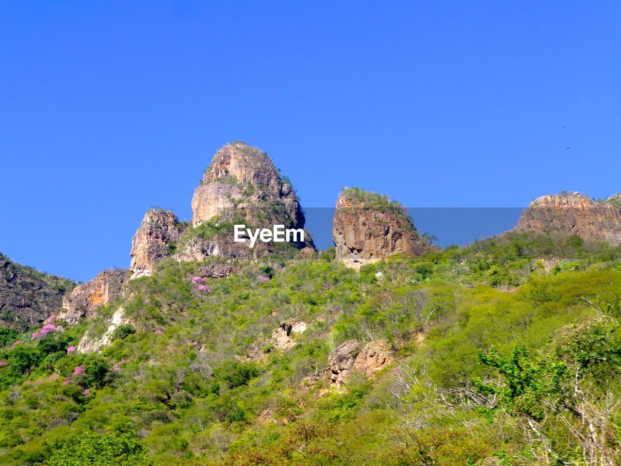 Scenic view of rocky mountains against blue sky