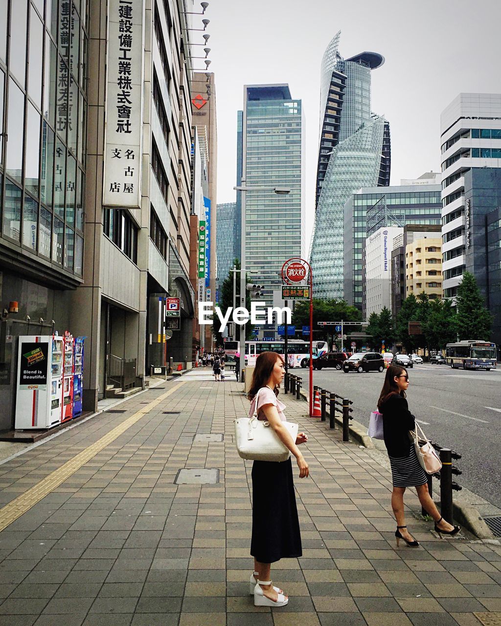 WOMAN STANDING ON CITY STREET