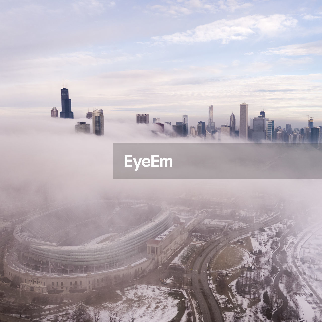 Aerial view of cityscape during against cloudy sky foggy weather