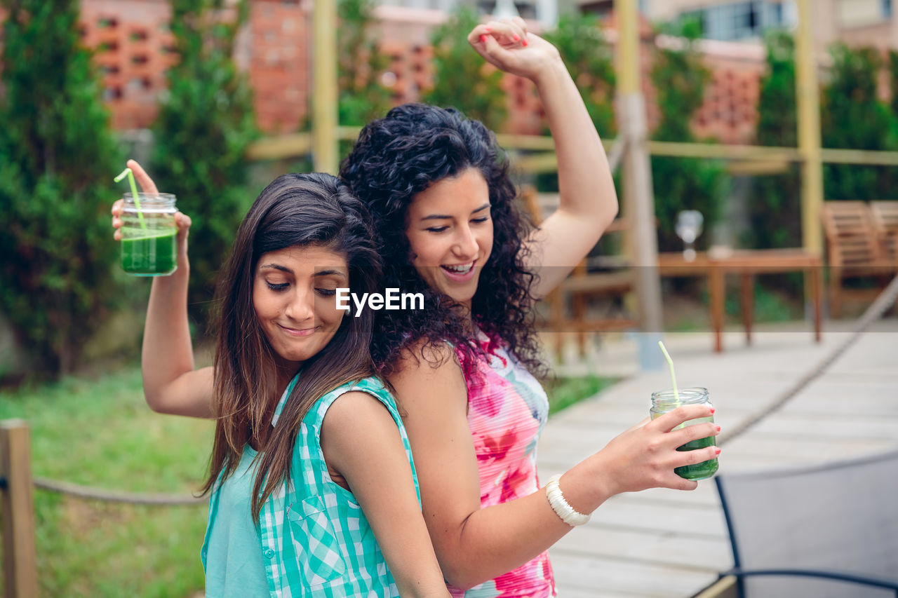 Friends dancing while having drink at restaurant