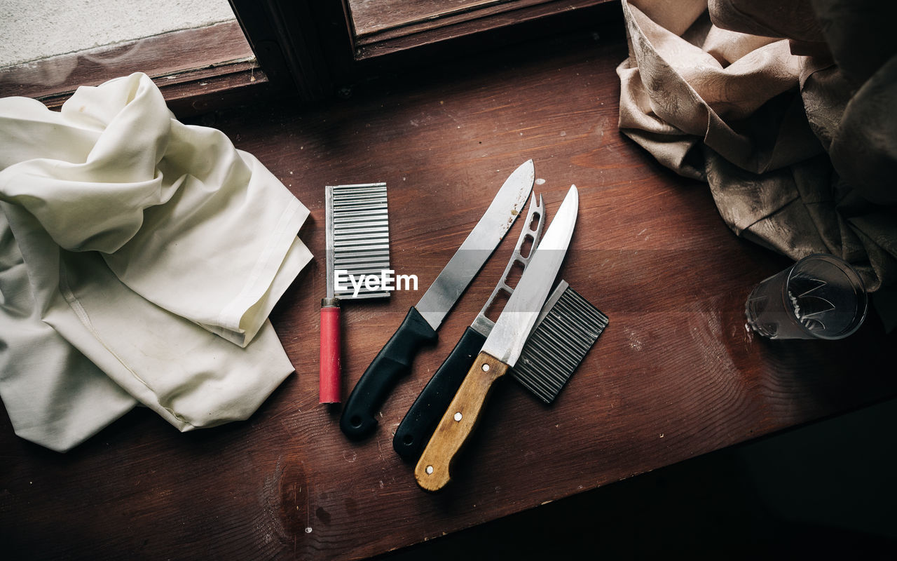 High angle view of combs with knives and textiles on table