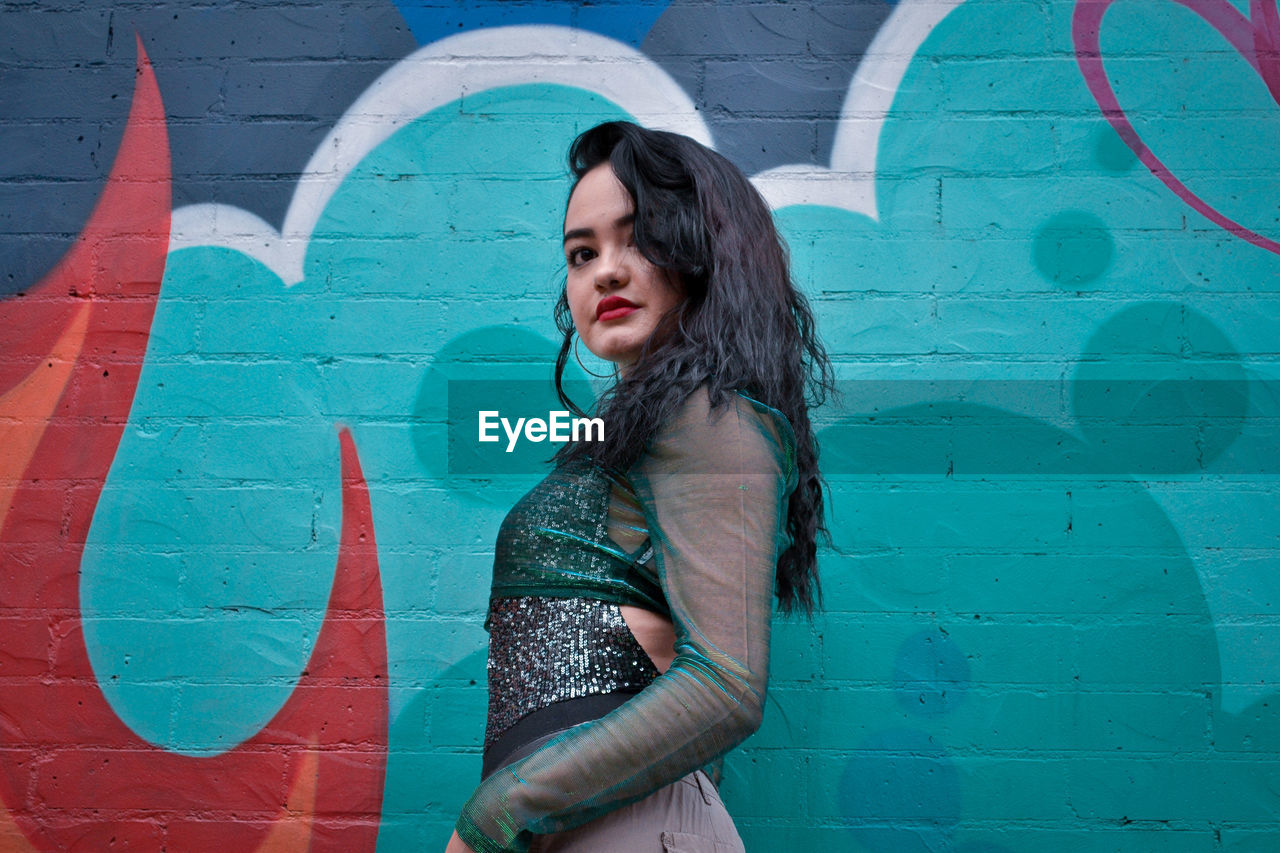 WOMAN STANDING AGAINST WALL