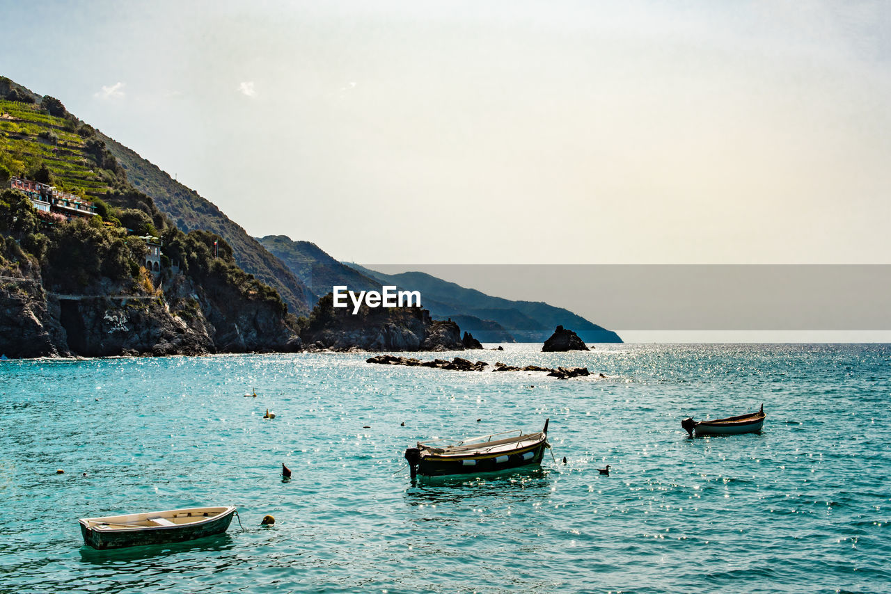 Boats moored on sea against sky