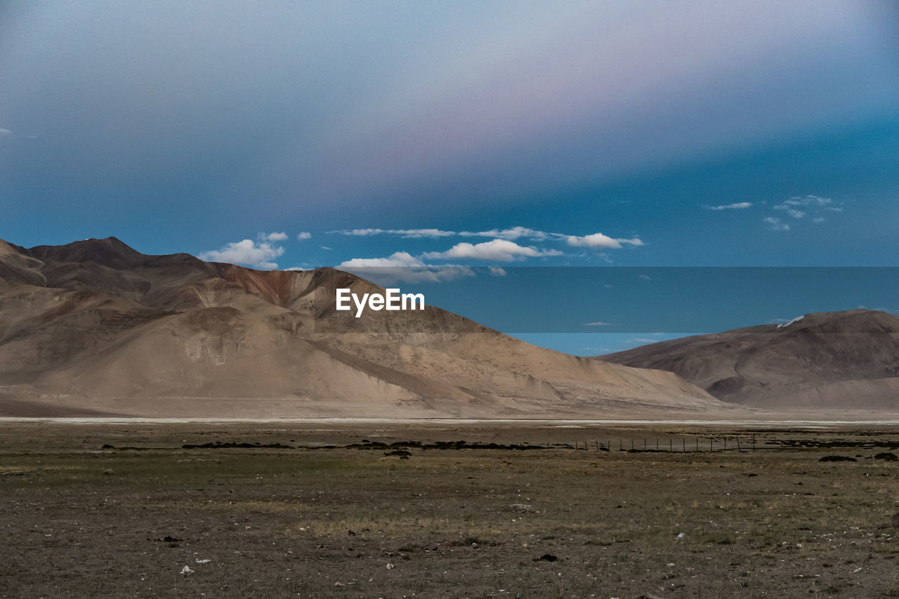 Countryside landscape against mountain range