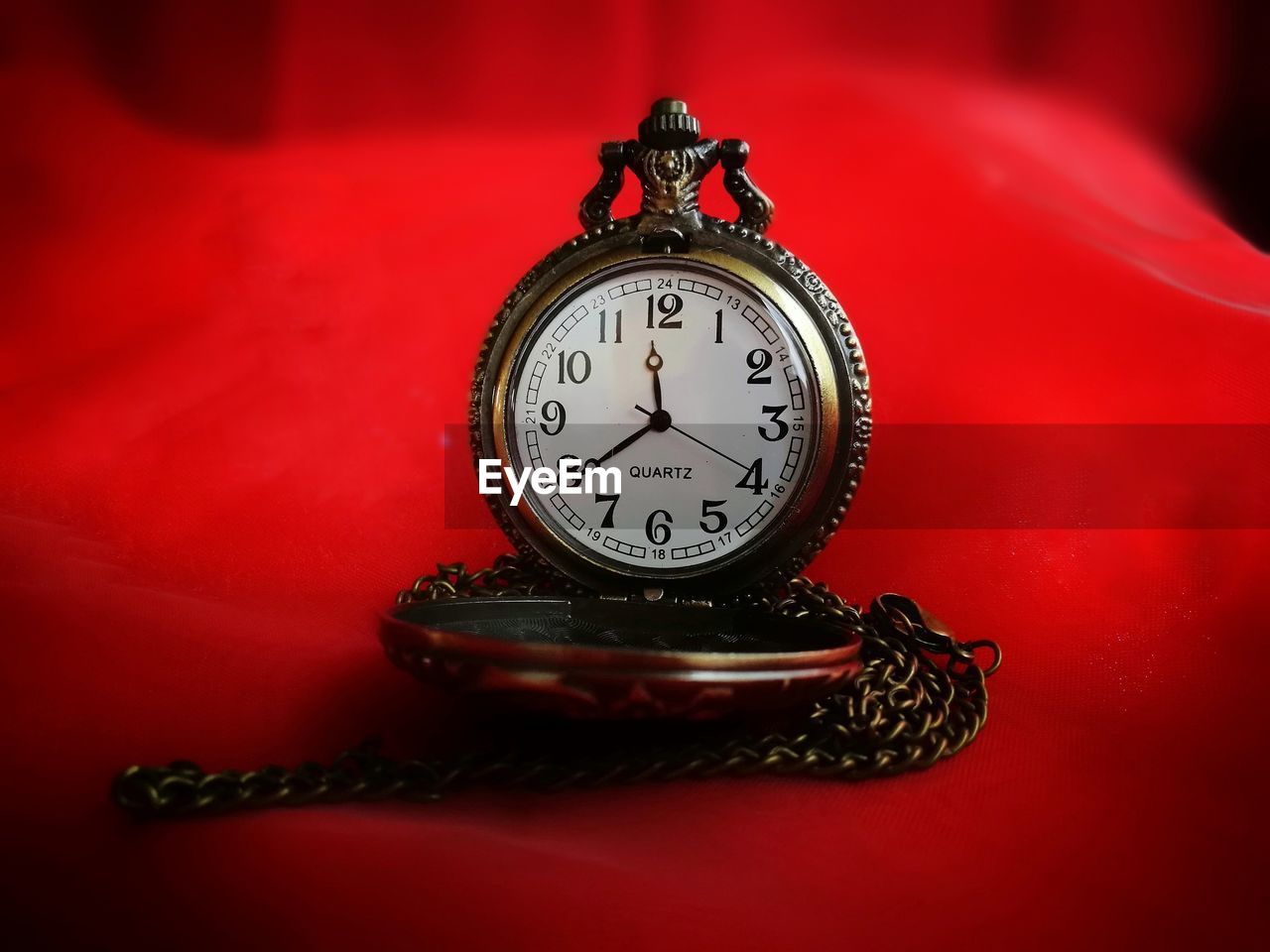 Close-up of clock on red table