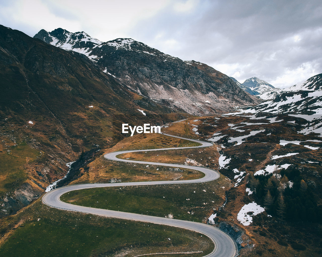 Scenic view of winding road by mountains during winter