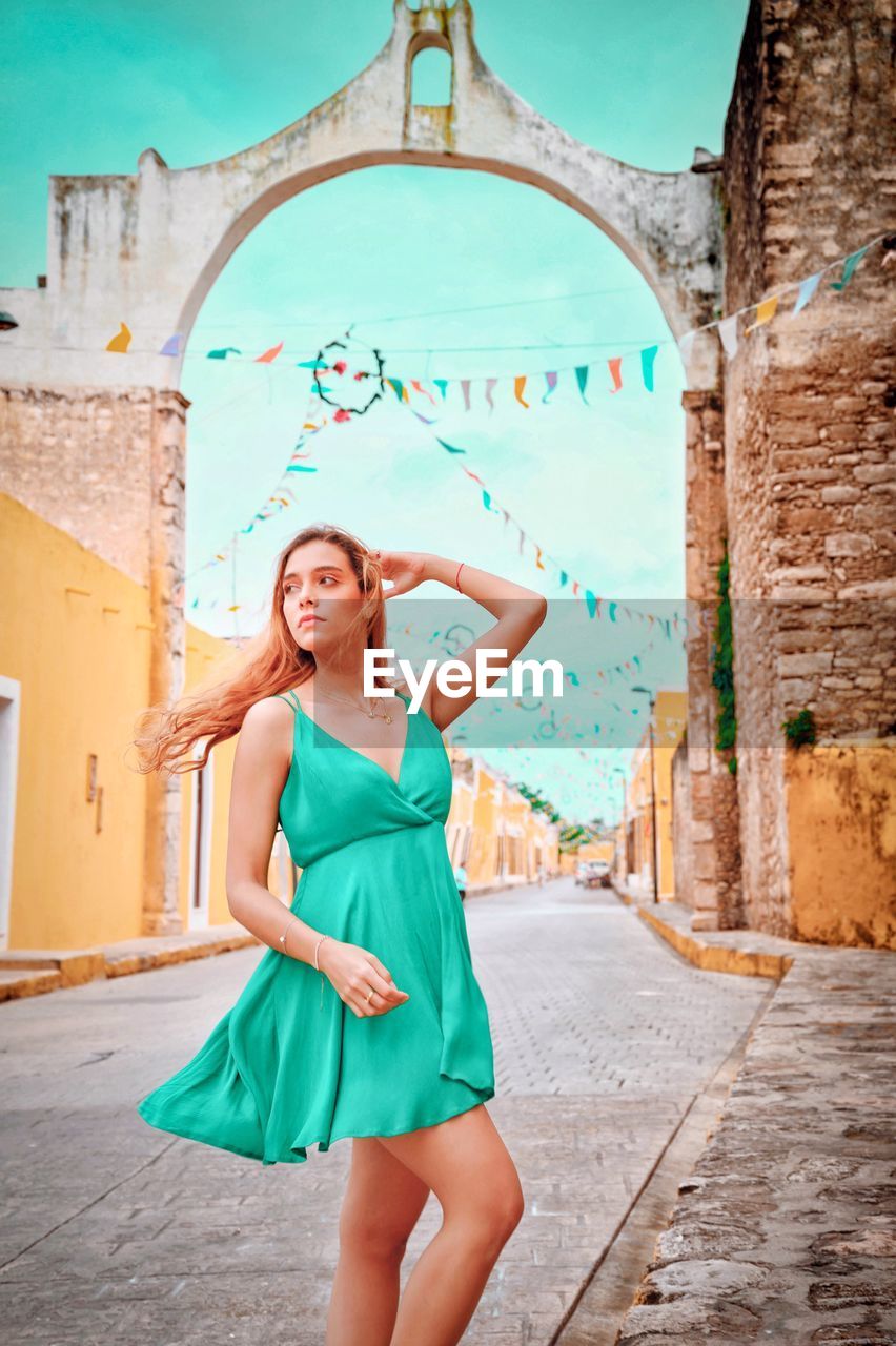 Full length of young woman standing against built structure in mexico