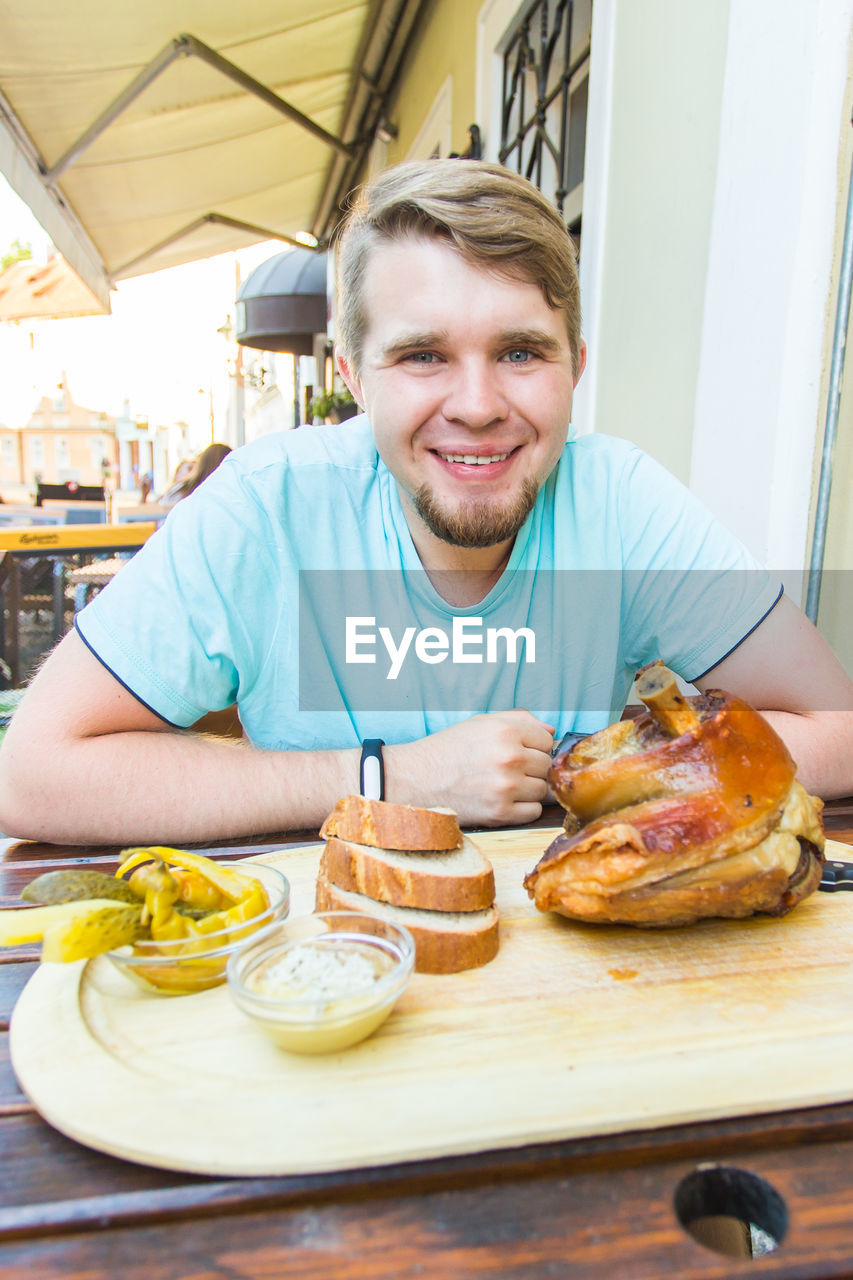 PORTRAIT OF A SMILING MAN WITH FOOD
