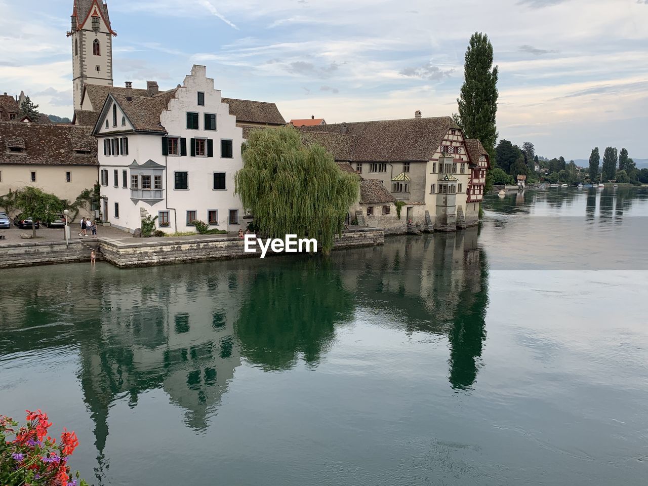 Buildings by lake against sky