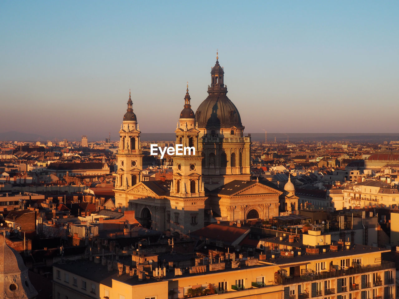 Church and buildings in city at sunset