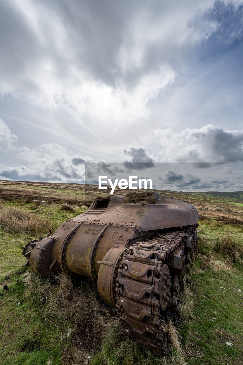 cloud, sky, rural area, environment, nature, landscape, land, grass, field, no people, vehicle, scenics - nature, abandoned, transportation, day, plant, outdoors, hill, non-urban scene, rock, sea, travel, mode of transportation, transport, tank