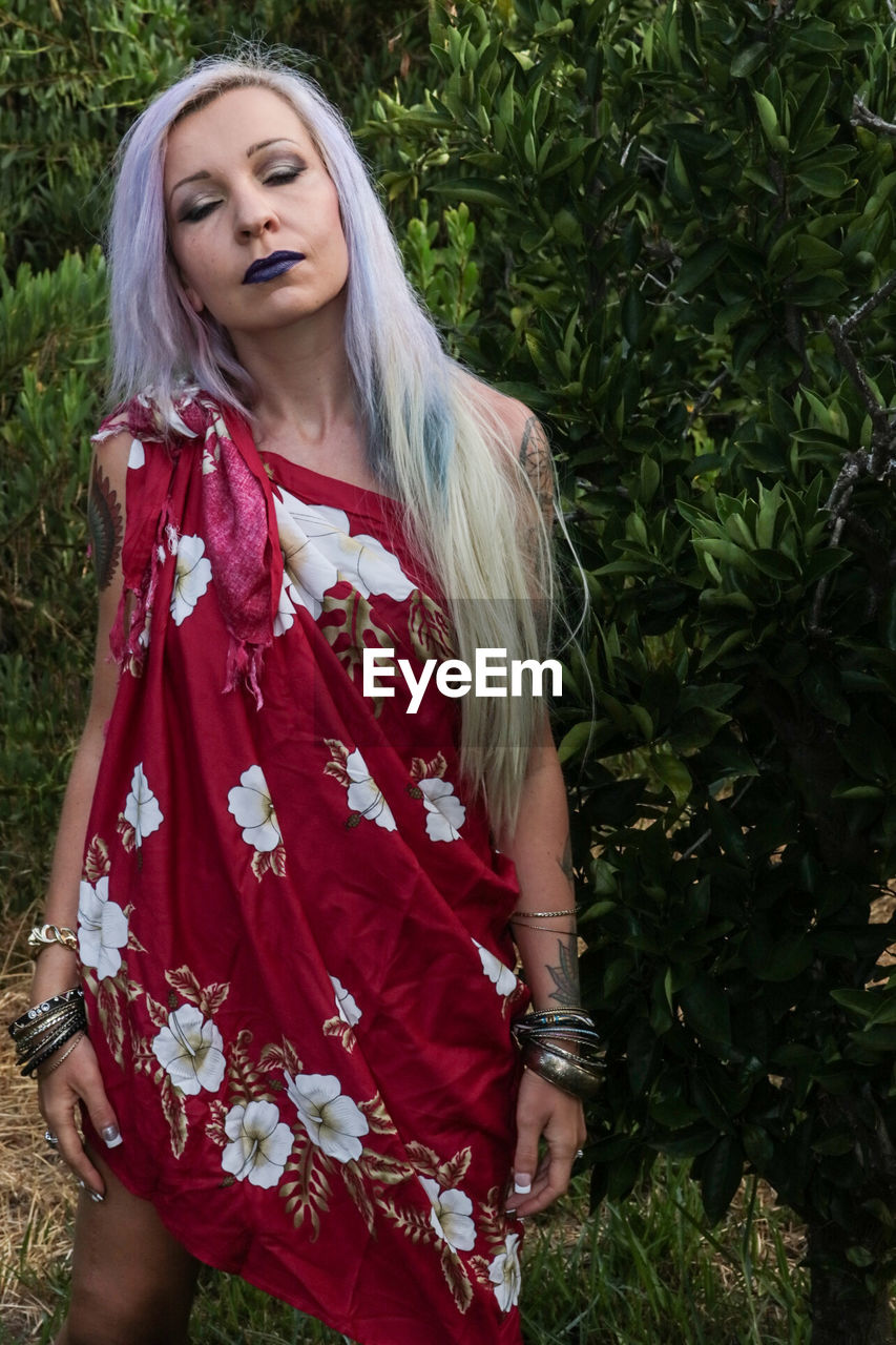 Woman in sarong standing on field at forest