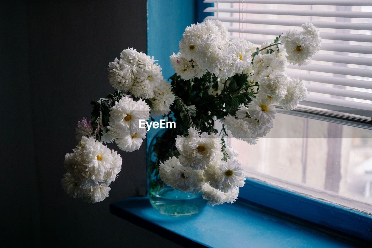 Close-up of white flower vase on windowsill