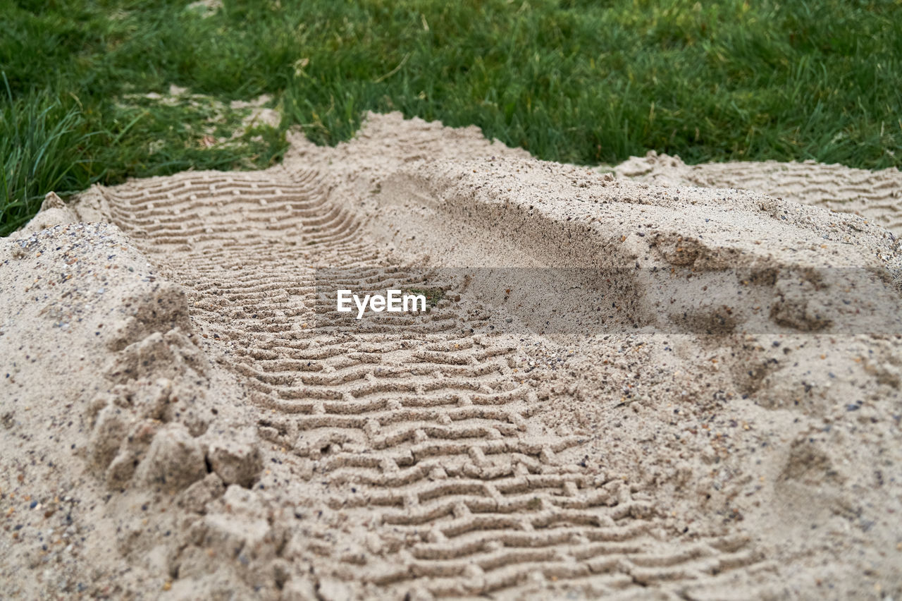 HIGH ANGLE VIEW OF TIRE TRACKS ON DIRT