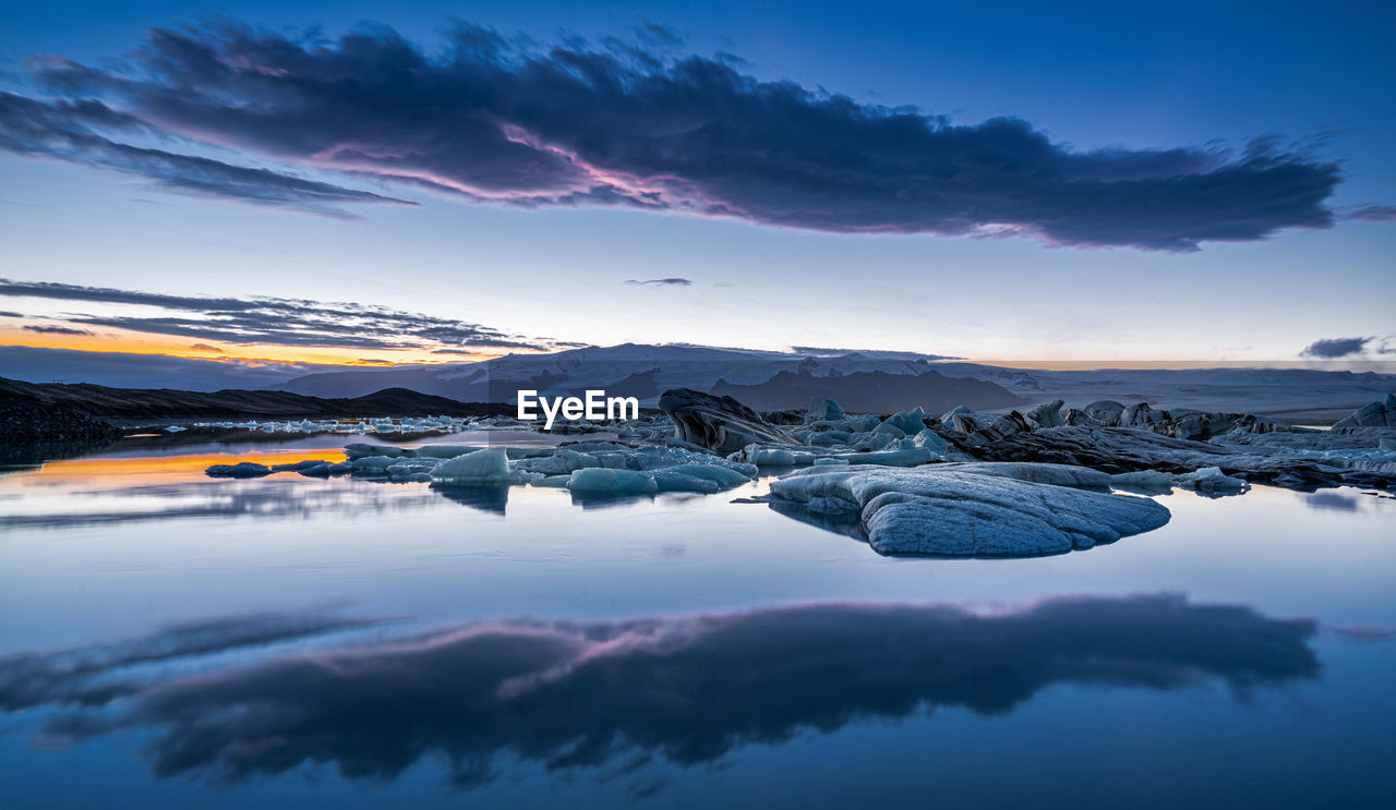 Scenic view of frozen lake against sky during sunset