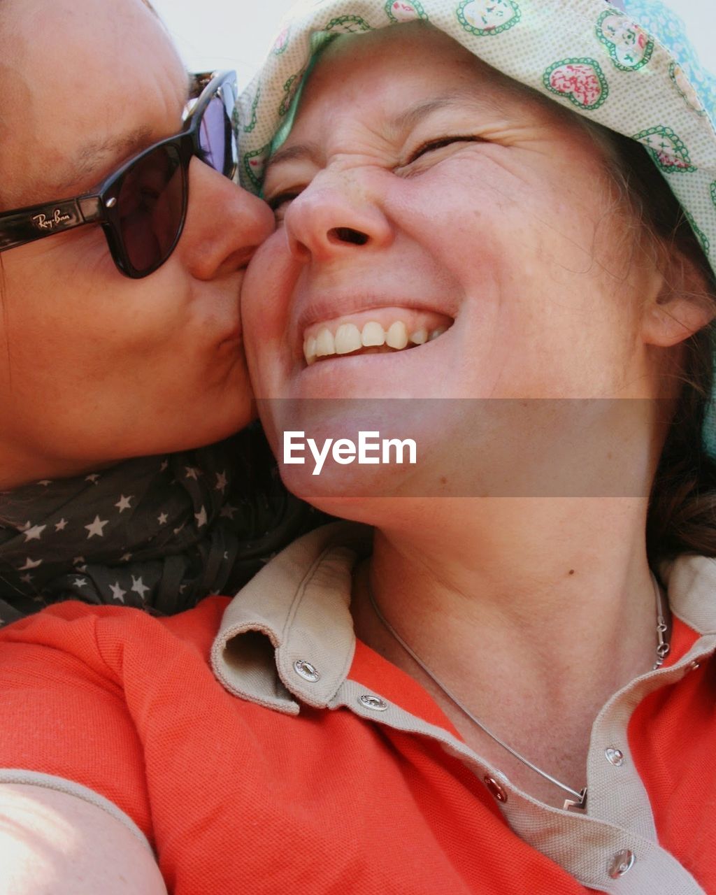 Close-up of woman kissing smiling mother on cheek