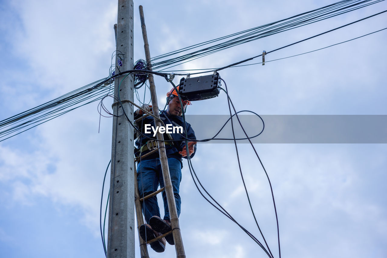 Low angle view of electricity pylon against sky