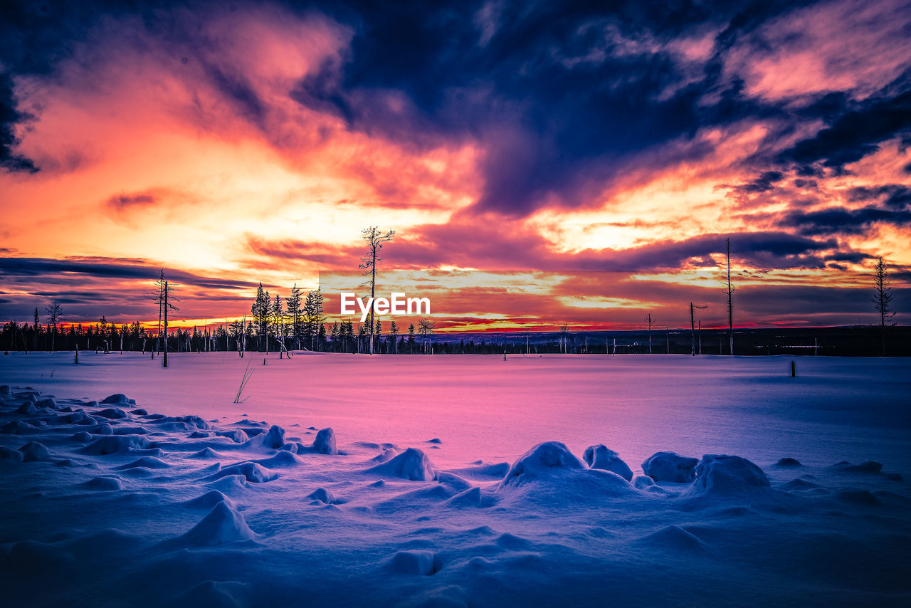 SCENIC VIEW OF FROZEN SEA AGAINST ORANGE SKY