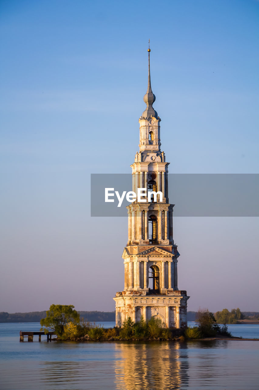 Beautiful christian church with golden domes among green trees.