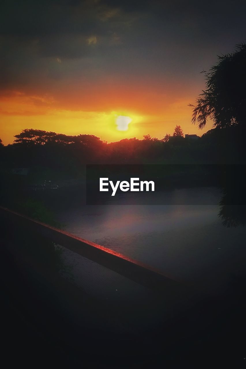 SCENIC VIEW OF LAKE AGAINST SKY AT SUNSET