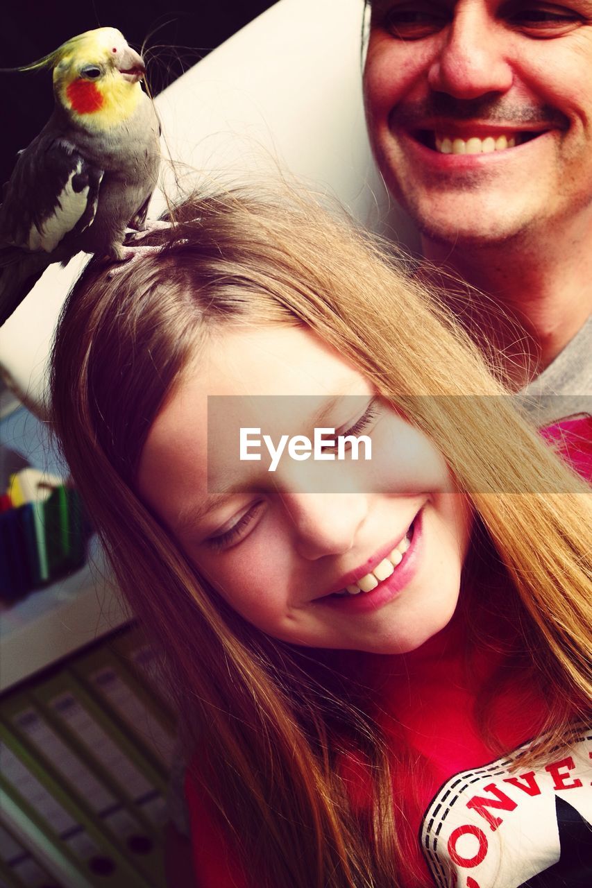 Close-up of a girl with bird on head