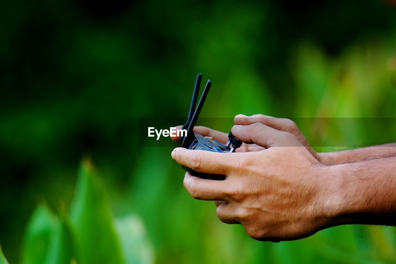 Close-up of man holding remote control