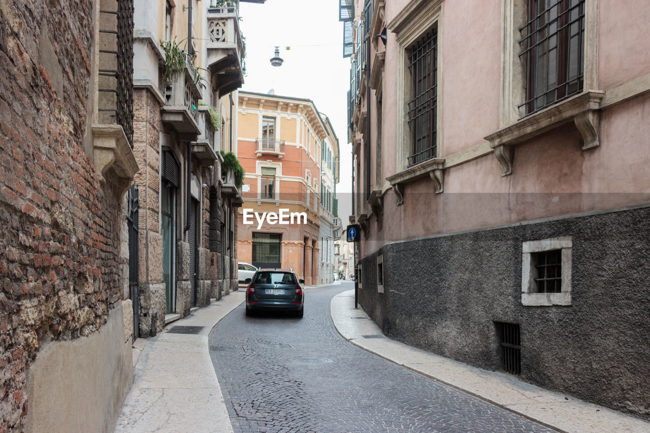 VEHICLES ON ROAD ALONG BUILDINGS