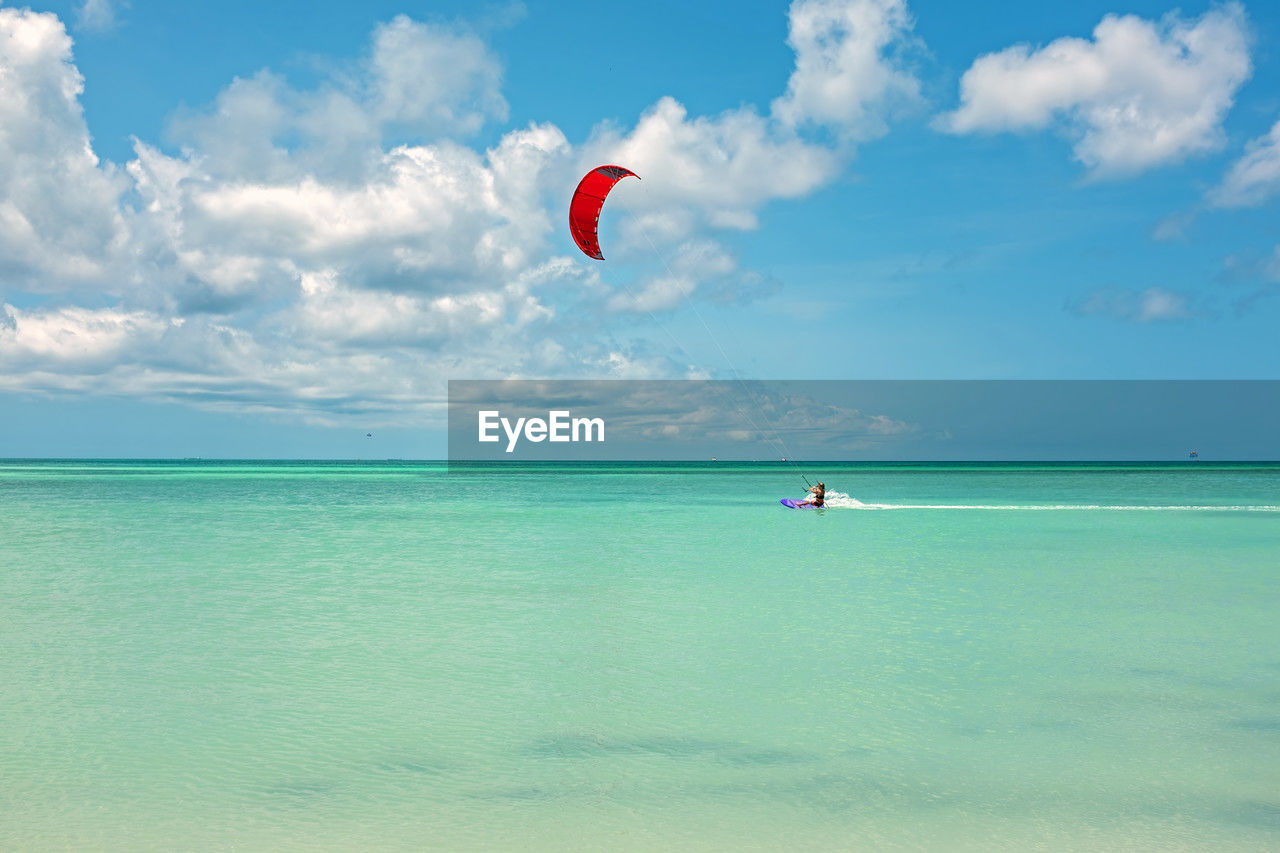 rear view of person paragliding over sea