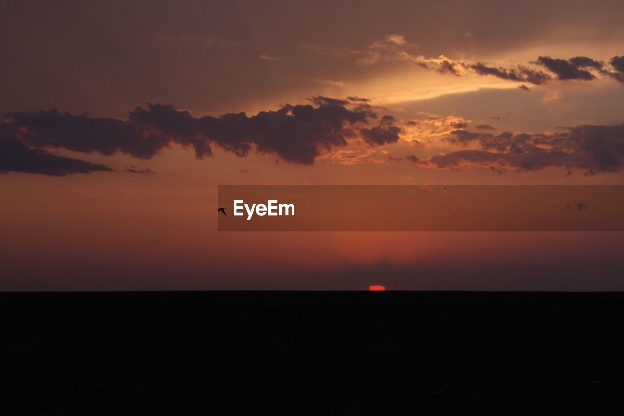 SCENIC VIEW OF SUNSET OVER SEA