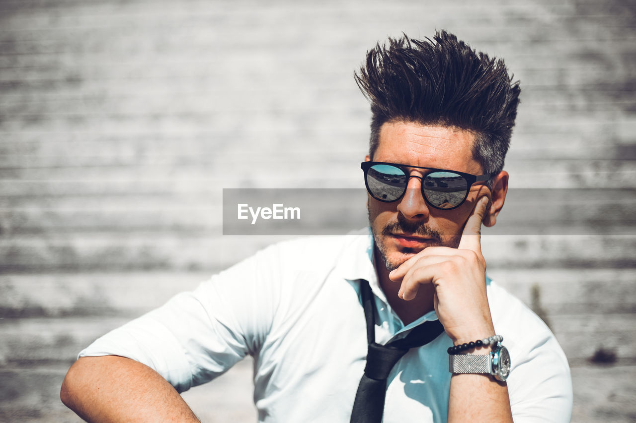 PORTRAIT OF YOUNG MAN WEARING EYEGLASSES