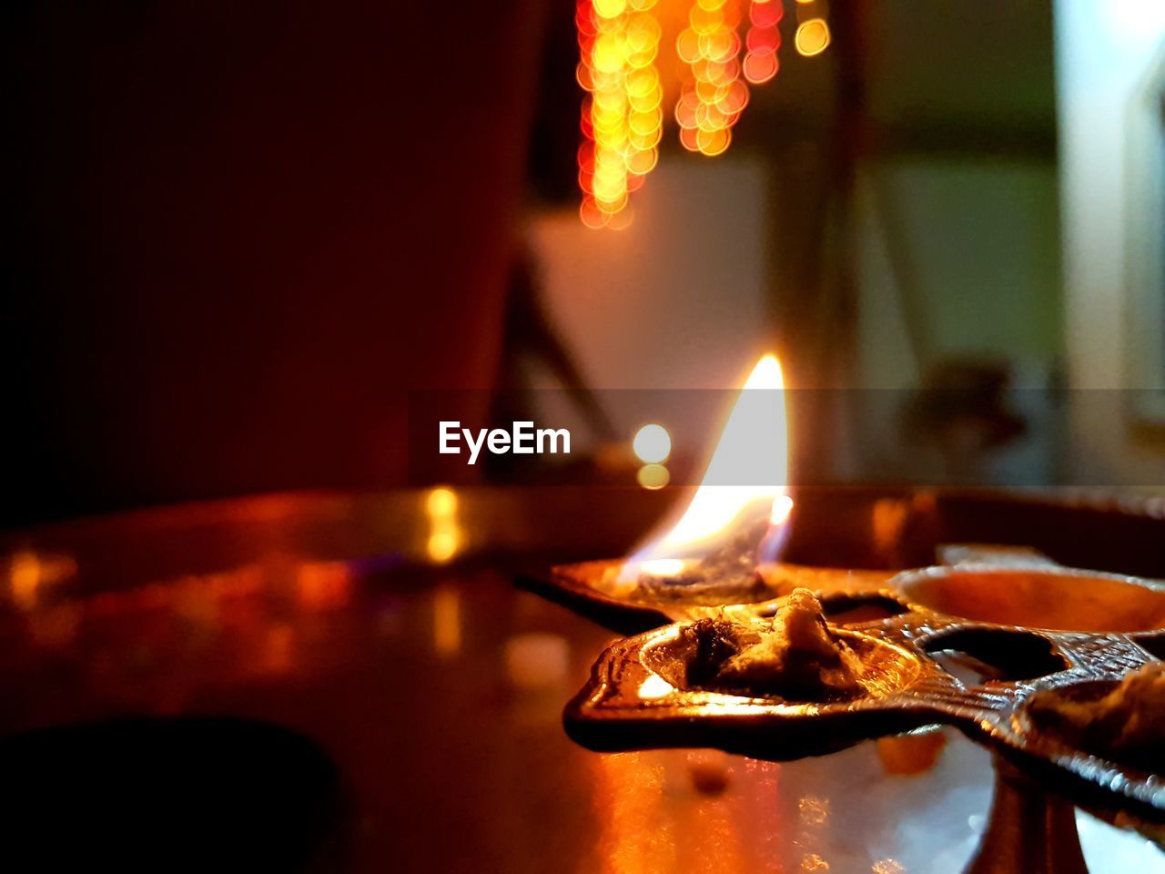 Close-up of illuminated diya in plate