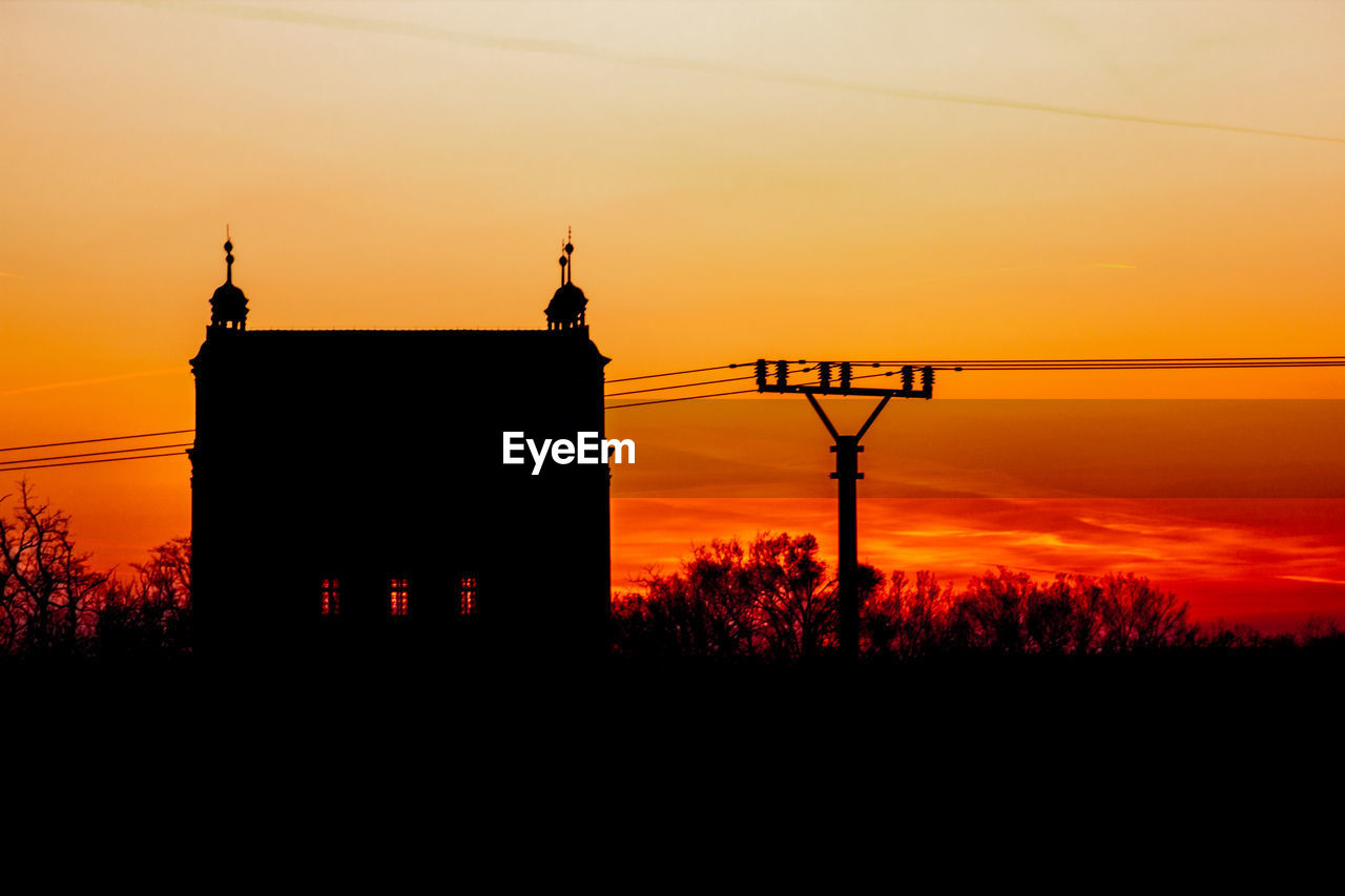 SILHOUETTE BUILDINGS AGAINST ORANGE SKY