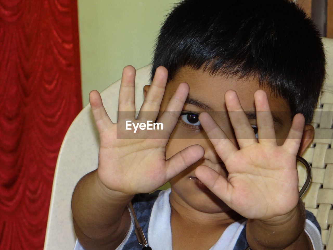 Portrait of a boy covering face